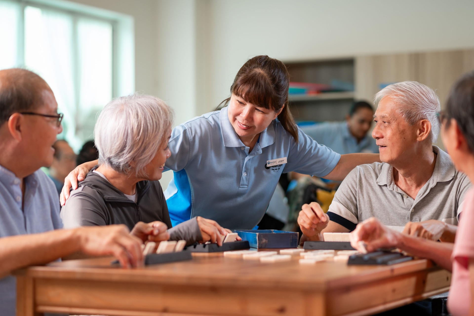 Caregiver interacting with seniors around a table